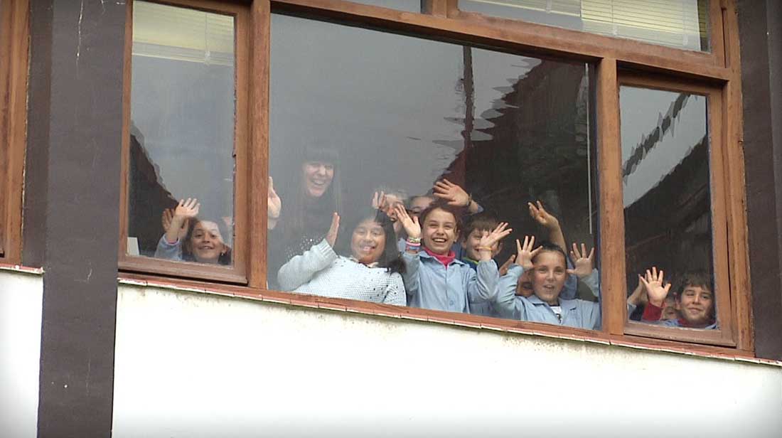 ikasleak leihotik agurtzen